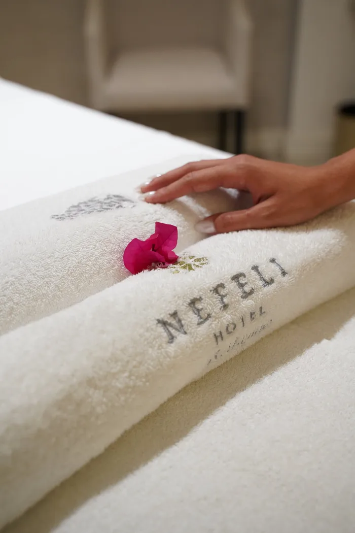 Rolled towels embroidered with the Nefeli Hotel logo