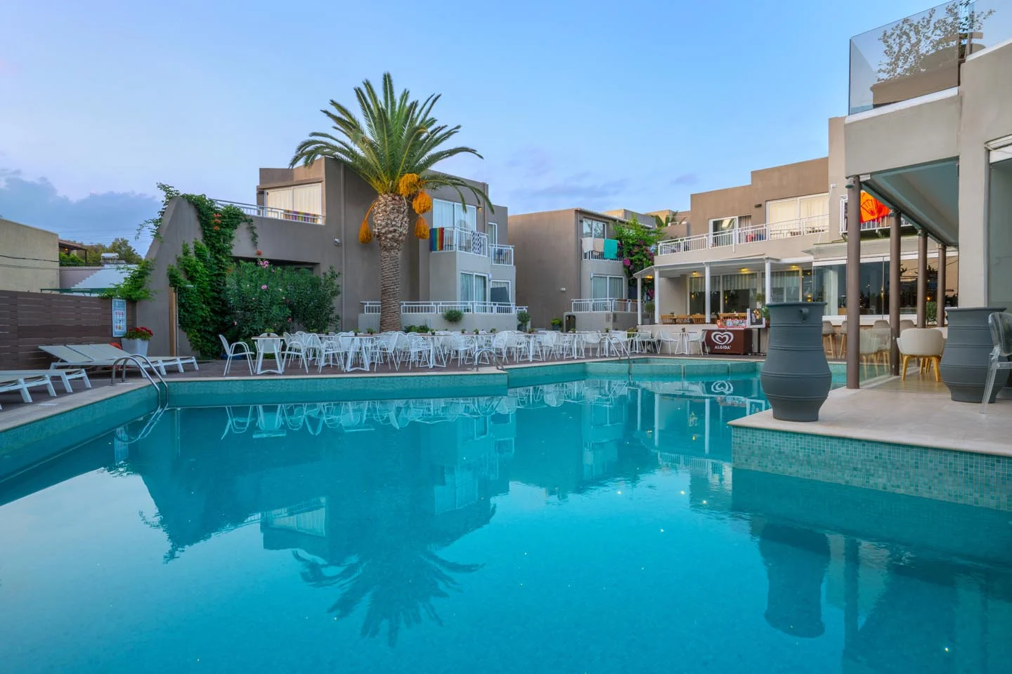 Sun loungers and rolled towels beside the Nefeli Hotel swimming pool